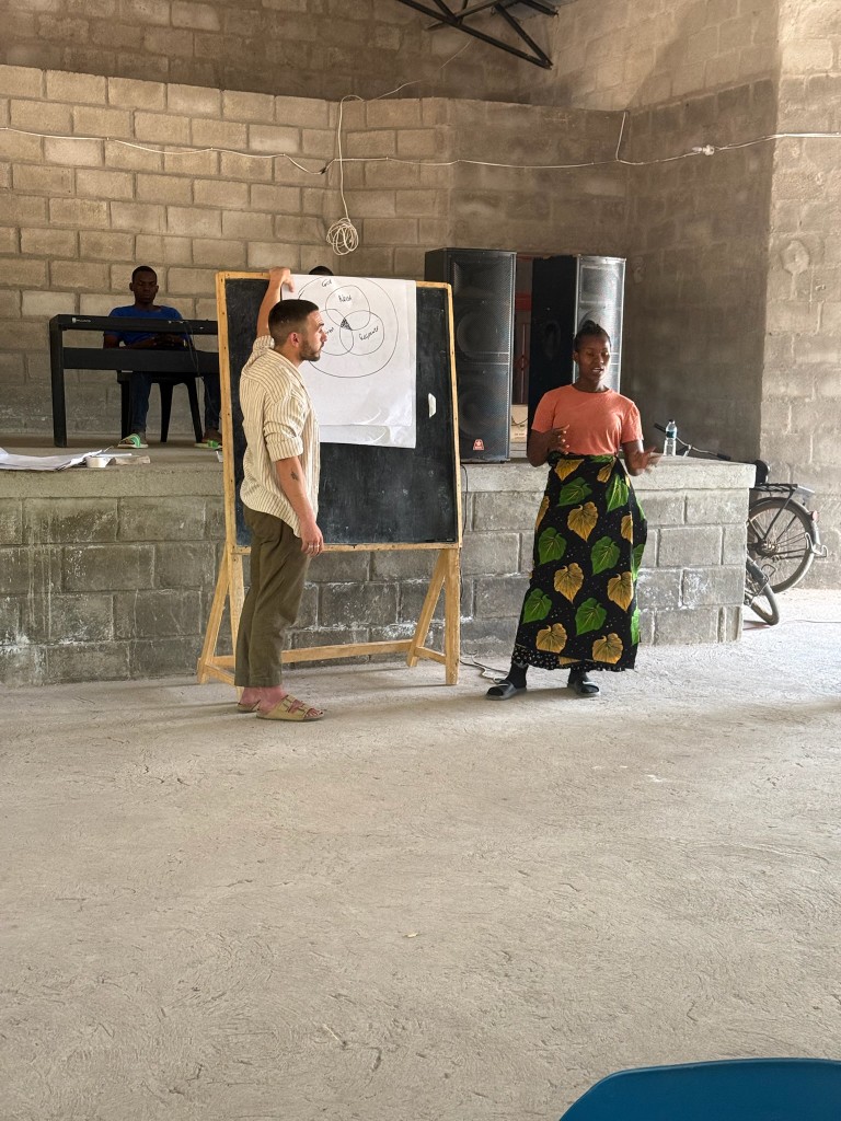 Matthew Hopkinson coaching community leaders at a chalkboard session in Malawi